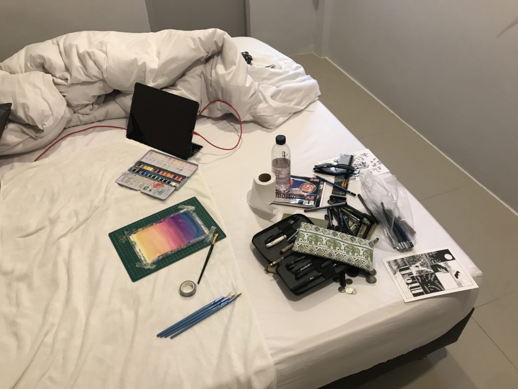 Art Supplies strewn across a bed in a hotel room.